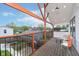 Wooden back deck with black metal railing and wooden supports and view of neighborhood at 1009 Harrison St, Indianapolis, IN 46202