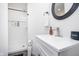 Modern bathroom featuring a white vanity, oval mirror, sleek faucet, and a walk-in shower with built-in shelves at 1009 Harrison St, Indianapolis, IN 46202