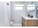Bathroom with wood vanity with white counter, illuminated mirror, and black and white tile floor at 1009 Harrison St, Indianapolis, IN 46202