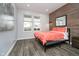 Bright bedroom with wood accent wall, two windows, and stylish decor create a cozy retreat at 1009 Harrison St, Indianapolis, IN 46202