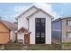 Modern two-story home with white siding, a dark window accent, and a rustic wood fence at 1009 Harrison St, Indianapolis, IN 46202