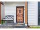 Close-up of a wooden front door with iron accents and a small porch with bench seating at 1009 Harrison St, Indianapolis, IN 46202