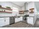 Modern kitchen featuring stainless steel appliances, herringbone tile backsplash and open wood shelving at 1009 Harrison St, Indianapolis, IN 46202