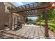 Covered patio with grill and outdoor dining area overlooking a spacious backyard and wooded scenery at 10504 Ruxton Ct, Fishers, IN 46040