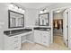 Well-lit bathroom features dual vanities, dark granite countertops, and access to a walk-in closet for convenience at 10504 Ruxton Ct, Fishers, IN 46040
