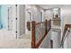 Hallway with rich, natural lighting, featuring a wood railing and a view into connecting rooms at 10504 Ruxton Ct, Fishers, IN 46040
