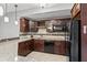 Kitchenette with dark wood cabinets, stainless appliances, granite counters, and tiled backsplash at 10504 Ruxton Ct, Fishers, IN 46040