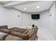 Basement living room with a neutral color palette, plush sofa, and mounted TV at 10504 Ruxton Ct, Fishers, IN 46040
