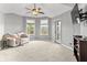 Bright bedroom featuring a ceiling fan, a comfortable seating area, and sliding glass door access to the outside at 10504 Ruxton Ct, Fishers, IN 46040