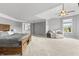 A spacious main bedroom offers a cozy seating area and features a ceiling fan for added comfort at 10504 Ruxton Ct, Fishers, IN 46040