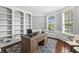 Stylish office space features custom built-ins, a wooden desk, and large windows for ample natural light at 10504 Ruxton Ct, Fishers, IN 46040