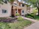 Inviting condo featuring a red front door, well-maintained landscaping, and a charming brick and siding exterior at 1098 Timber Creek Dr # 2, Carmel, IN 46032