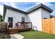 View of the fenced backyard featuring a small deck with outdoor seating and artificial grass at 1112 Spann Ave, Indianapolis, IN 46203