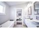 Modern bathroom with a freestanding tub and view into the bright bedroom at 1112 Spann Ave, Indianapolis, IN 46203