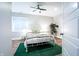 Bright bedroom with white metal bed frame, ceiling fan, a green rug, and hardwood floors at 1112 Spann Ave, Indianapolis, IN 46203