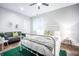 Sunlit bedroom features a white metal bed frame, ceiling fan, a sofa and hardwood floors at 1112 Spann Ave, Indianapolis, IN 46203