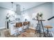 Kitchen with white cabinets, black countertops, bar seating, and adjacent bar table at 1112 Spann Ave, Indianapolis, IN 46203