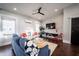 Bright living room with a ceiling fan, hardwood floors, a blue couch, and a large TV at 1112 Spann Ave, Indianapolis, IN 46203