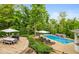Backyard oasis with a pristine pool, lounge chairs, manicured landscaping, and outdoor dining area for entertaining at 11245 Old Stone Dr, Indianapolis, IN 46236