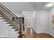 Bright foyer with hardwood floors, white walls, staircase with dark metal railings, and a modern chandelier at 11245 Old Stone Dr, Indianapolis, IN 46236
