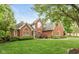 Beautifully landscaped red brick home with a green lawn and stylish architectural details, creating inviting curb appeal at 11245 Old Stone Dr, Indianapolis, IN 46236
