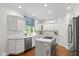 Stylish kitchen with a marble island, white cabinetry, and stainless steel appliances, creating a chef's dream space at 11245 Old Stone Dr, Indianapolis, IN 46236