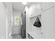 Functional laundry room includes a stacked washer and dryer, overhead cabinets, seating area, and natural light at 11245 Old Stone Dr, Indianapolis, IN 46236