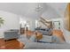 Spacious living room with a view to the kitchen, elegant staircase, and ample natural light, perfect for relaxation at 11245 Old Stone Dr, Indianapolis, IN 46236