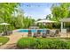 Refreshing pool with lounge chairs, umbrella, and stone waterfall feature surrounded by lush greenery and well-manicured landscaping at 11245 Old Stone Dr, Indianapolis, IN 46236