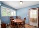 Cozy dining area with a wooden table set, natural light from a window, and access to the home's back entrance at 11600 N 100 E, Morristown, IN 46161