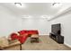 Finished basement includes a red sofa, tan chair, and large TV at 12152 Teal Ln, Carmel, IN 46032
