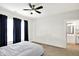 Bright bedroom with ceiling fan, double windows with blue curtains, and access to bathroom at 12152 Teal Ln, Carmel, IN 46032