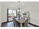 Elegant dining room featuring a modern chandelier and large window with blue curtains at 12152 Teal Ln, Carmel, IN 46032