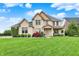 Beautiful two story brick home with a manicured lawn, landscaping and a welcoming front porch at 12152 Teal Ln, Carmel, IN 46032