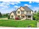 Beautiful two story brick home with a manicured lawn, landscaping and a welcoming front porch at 12152 Teal Ln, Carmel, IN 46032