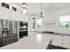 Modern kitchen featuring stainless steel appliances, a stylish island with a quartz countertop, and pendant lighting at 12152 Teal Ln, Carmel, IN 46032