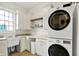 Functional laundry room featuring modern washer and dryer, ample storage, and natural light at 12152 Teal Ln, Carmel, IN 46032