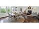 Open-concept living space with hardwood floors, large windows, a dining area, and a cozy fireplace at 12152 Teal Ln, Carmel, IN 46032