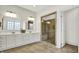 Bright main bathroom with double vanity, a large mirror and glass shower at 12152 Teal Ln, Carmel, IN 46032