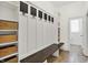 Organized mudroom featuring built-in storage, hooks, and seating, with tile flooring and natural light at 12152 Teal Ln, Carmel, IN 46032
