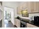 Bright wet bar with cream-colored cabinets, black countertop and beverage refrigerator at 12152 Teal Ln, Carmel, IN 46032