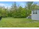 Beautiful backyard featuring lush green grass, mature trees, and a cozy deck accessible from the main house at 12811 Corydon Dr, Fishers, IN 46037