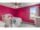Bedroom with pink walls, a queen bed, a ceiling fan, and a window at 12811 Corydon Dr, Fishers, IN 46037