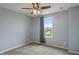 Bedroom with blue walls, neutral carpet, a ceiling fan, and a window with a view of the neighborhood at 12811 Corydon Dr, Fishers, IN 46037