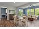 Bright dining area featuring a dark wood table, cream chairs, and large windows showcasing lush greenery at 12811 Corydon Dr, Fishers, IN 46037