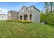 Elegant exterior showcasing a stone facade, covered porch with arched openings, and professional landscaping at 12811 Corydon Dr, Fishers, IN 46037