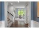 Hallway with hardwood floors and staircase that leads to the light filled living room with large windows at 12811 Corydon Dr, Fishers, IN 46037
