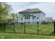 Backyard view featuring a deck, expansive lawn, and wrought iron fence at 12811 Corydon Dr, Fishers, IN 46037