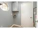 Laundry room with storage cabinet, gray walls, and wood-look flooring at 1283 Easton Point Dr, Greenwood, IN 46142