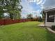 Large backyard with a green lawn, a privacy fence, a sunroom, and mature trees at 1513 Ashley Dr, Lebanon, IN 46052